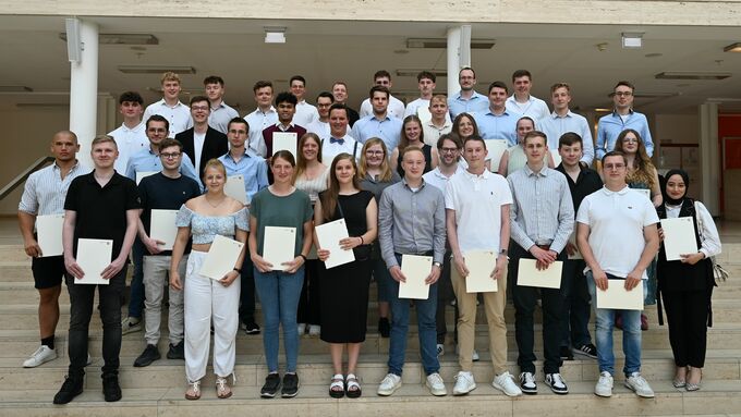 Zum gemeinsamen Gruppenfoto stellten sich die frisch ernannten Geoinformatiker- und Vermesseungstechniker:innen nach der Zeugnisausgabe im Foyer der Bezirksregierung Münster auf.