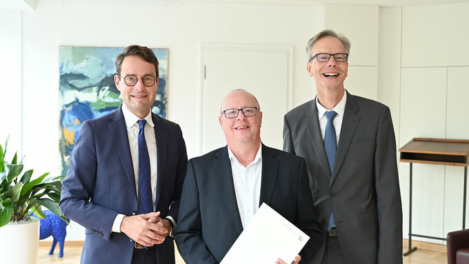 Regierungspräsident Andreas Bothe (l.) und Regierungsvizepräsident Dr. Ansgar Scheipers (r.) gratulieren Wolfgang Weßling (Mitte) herzlich zum 40-jährigen Dienstjubiläum.